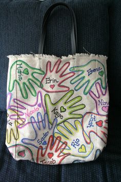 a handbag with writing on it sitting on a couch