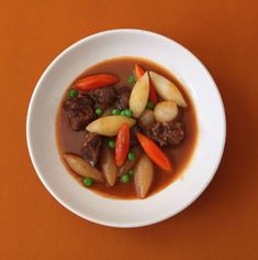 a white bowl filled with meat and vegetables