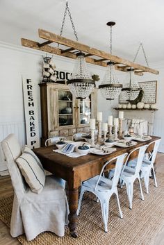 a dining room table with chairs and chandelier hanging from it's ceiling