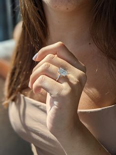 a close up of a person wearing a ring with a diamond on it's finger