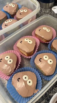 some cupcakes with chocolate frosting and googly eyes are in plastic containers