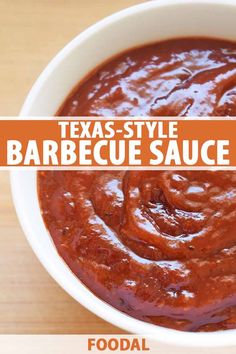 a white bowl filled with barbecue sauce on top of a wooden table