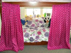 a bed with pink curtains and polka dots on it