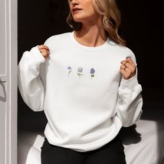 "Introducing our Embroidered Blue Flowers Unisex Sweatshirt - the epitome of comfort and style in one. Each stitch tells a story of elegance, making it a must-have for those who appreciate the beauty in life's simple pleasures.This medium-weight sweater boasts a unisex fit, making it a versatile addition to any wardrobe. Whether you're dressing up for a sophisticated look or opting for a casual chic outfit, this crewneck sweatshirt effortlessly complements any style. Ideal for anyone who loves flowers/plants or anyone seeking a comfortable designer-inspired top.  Perfect for those who seek a blend of comfort and sophistication, this sweatshirt is more than just clothing; it's a statement of timeless values. Discover the joy of simplicity and let this piece become a cherished staple in your White Floral Embroidery Sweatshirt For Spring, White Relaxed Fit Sweatshirt With Floral Embroidery, Relaxed Fit Crew Neck Sweatshirt With Floral Embroidery, Relaxed Fit Floral Embroidery Crew Neck Sweatshirt, Floral Embroidered Crew Neck Sweatshirt With Relaxed Fit, White Floral Embroidery Sweatshirt With Relaxed Fit, White Floral Embroidered Sweatshirt Relaxed Fit, Spring Long Sleeve Tops With Custom Embroidery, White Floral Embroidered Sweatshirt With Relaxed Fit