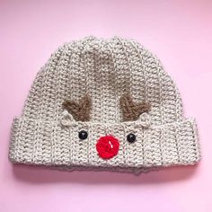 a knitted reindeer hat with red nose and antlers