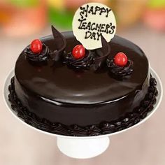 a happy teacher's day chocolate cake with cherries on top and a sign that says happy teachers day