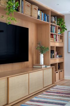 a living room filled with furniture and a flat screen tv on top of a wooden shelf