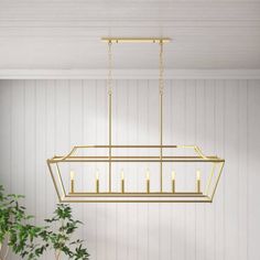 a gold chandelier hanging from the ceiling in a room with white walls and flooring