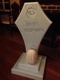 a white vase with writing on it sitting on a table in front of a fireplace