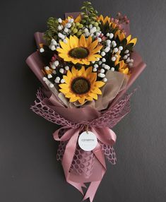 a bouquet of sunflowers tied to a wall with a price tag on it