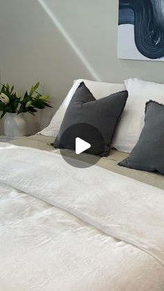 a bed with white sheets and black pillows