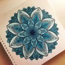 a spiral notebook with an intricate blue flower design on the front and back cover, sitting on a table