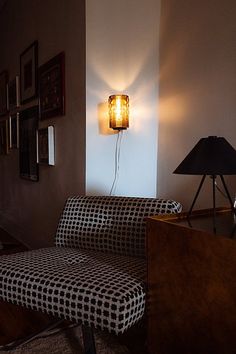 a living room with a couch, lamp and pictures on the wall