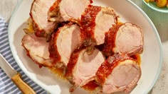 sliced pork with sauce on a white plate