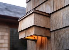 a light that is on in the side of a building next to a wall with wood panels