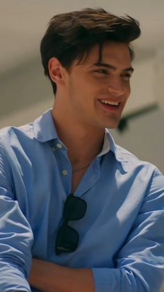 a man in a blue shirt and tie smiling