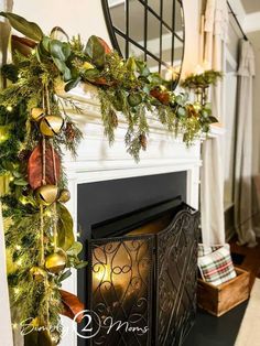 a fireplace decorated for christmas with greenery and garland on it's mantel