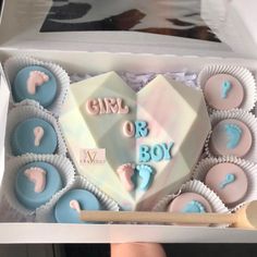 a box filled with blue and pink cupcakes next to a sticker that says girl or boy