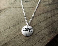 "A tiny dragonfly necklace made of pure silver. The dragonfly is symbolic in many cultures around the world and it represents prosperity, good luck, strength and harmony. I do a larger version of this design which you can see here: https://www.etsy.com/lulubugjewelry/listing/127418415/dragonfly-necklace-silver-dragonfly The pendant is approximately 3/8\" in diameter, or 10mm. Entirely hand made by me, starting with my original drawing. Then I make the stamping tool and create the piece. The pend Dainty Sterling Silver Dragonfly Jewelry, Dainty Silver Dragonfly Jewelry, Dragonfly Shaped Sterling Silver Jewelry Gift, Sterling Silver Dragonfly Jewelry Gift, Spiritual Dragonfly Jewelry Gift, Adjustable Sterling Silver Dragonfly Necklace, Adjustable Dragonfly Necklace For Gifting, Adjustable Dragonfly Necklace For Gift, Handmade Dragonfly Necklace For Gifting