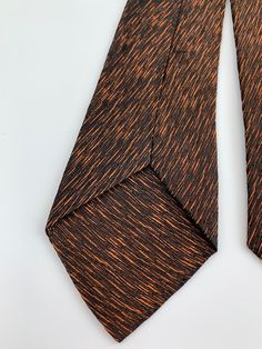 1960'S slim tie in an interesting deep brown background with metallic threads of gold. Label reads: TIE CITY NYC This tie is in EXCELLENT VINTAGE CONDITION. no issues to note.. There is no fabric content label. It feels like acetate, rayon or a blend of both Measurements: Total length: 53 inches long Width at widest point: 2-1/2 inches wide Width at the narrow end: 1-3/4 inches wide Classic Brown Ties For Party, Classic Brown Ties For Office, Elegant Brown Party Ties, Elegant Brown Formal Ties, Vintage Brown Ties For Formal Occasions, Classic Brown Neckwear With Ties, Vintage Brown Tie For Business, Luxury Brown Elegant Tie, Vintage Brown Ties For Business