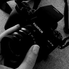 a person holding a camera in their hand on the floor next to a carpeted area