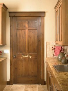 a wooden door in a kitchen with granite counter tops