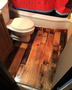 a bathroom with wooden floors and a toilet