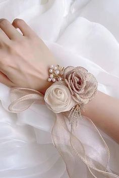 a close up of a person's hand wearing a bracelet with flowers on it