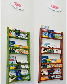 two wooden bookshelves with children's books on them against a white wall