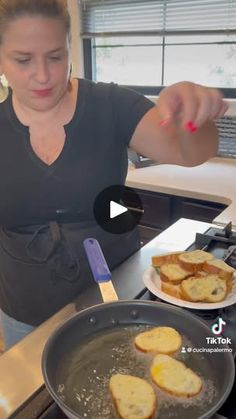 a woman cooking food on top of a stove next to a pan filled with bread