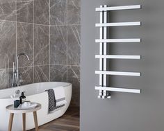 a white bath tub sitting next to a wall mounted radiator