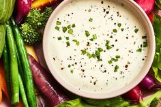 a bowl of ranch dressing surrounded by vegetables