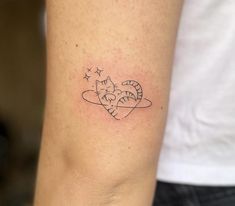 a small tattoo on the arm of a woman with a cat and stars in it