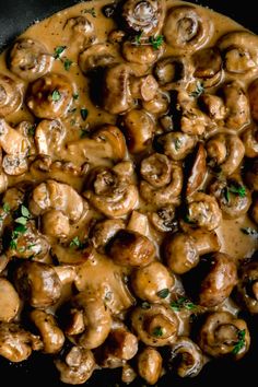 a skillet filled with mushrooms covered in gravy