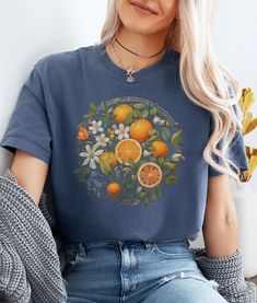 Embrace floral mystique in our citrus blossom tee, where vibrant wildflowers dance alongside zesty citrus blooms under the moon's soft glow. Let the enchantment of nature illuminate this cozy design. ★ Fabric ★ The Comfort Colors 1717 tee is made with medium fabric (6.1 oz/yd² (206.8 g/m consisting of high quality, 100% ring-spun US cotton for long-lasting comfort. Made using 100% US cotton that is ethically grown and harvested. ★ Fit ★ The relaxed fit keeps the wearer comfy in both casual and s Vintage Fruit Print Crew Neck Tops, Vintage Crew Neck Tops With Fruit Print, Spring Fruit Print Crew Neck Tops, Multicolor Fruit Print Spring Top, Multicolor Fruit Print Tops For Spring, Spring Fruit Print Relaxed Fit Tops, Spring Fruit Print Tops With Relaxed Fit, Spring Relaxed Fit Tops With Fruit Print, Blue Floral Print T-shirt For Fall