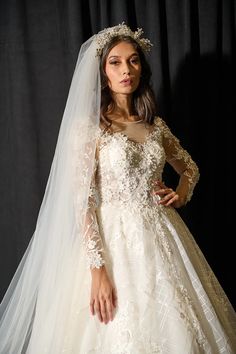 a woman in a wedding dress with a veil on her head is posing for the camera