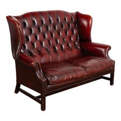 a red leather couch sitting on top of a wooden frame