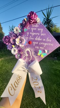 someone is holding up a purple graduation cap that has flowers on it and the words