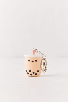 a small cup with a face on it and a keychain hanging from the side