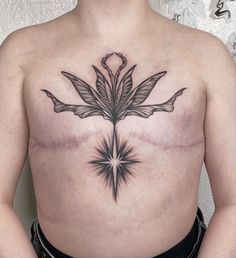 a man's chest with an artistic flower tattoo on his left side ribcage