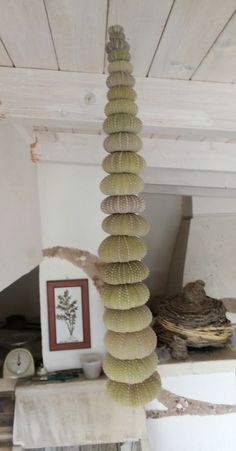 a very tall white vase sitting in the middle of a room next to a table