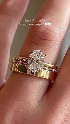 a woman's hand with a gold ring and diamond engagement ring on her finger