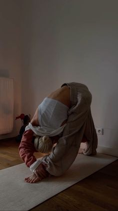 a woman and child are doing yoga in front of a heater on the floor