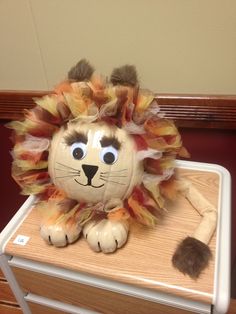 a stuffed lion sitting on top of a table