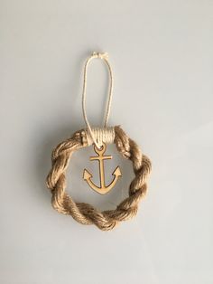 an anchor is hanging from a rope on a white surface with a knot around it