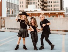 three children are posing for a photo in the parking lot with their arms around each other