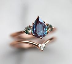 three different colored stones are on top of each other in this rose gold band ring