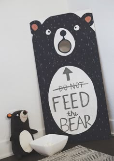 a black bear is next to a sign that says don't feed the bear