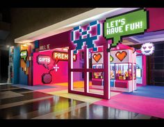 the entrance to an arcade game store decorated in pixel art and neon colors with words that spell out, let's have fun