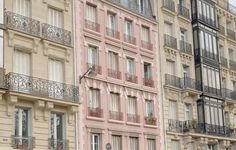 several different colored buildings with balconies and windows